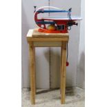 A Hegner Multicut-2 workshop electric fret saw mounted on a simple pine stand, together with a