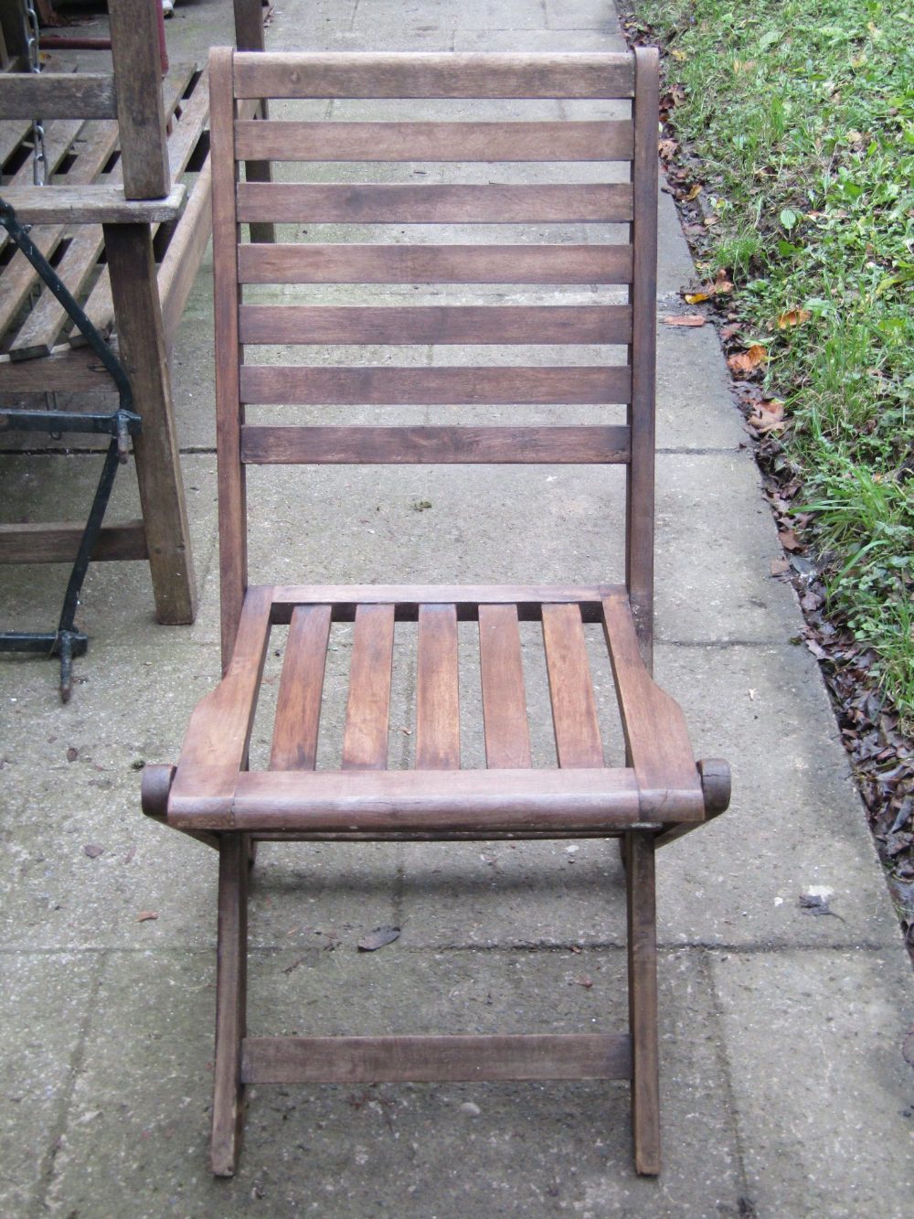 A set of four contemporary stained hardwood folding garden chairs with slatted seats and backs