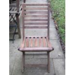 A set of four contemporary stained hardwood folding garden chairs with slatted seats and backs