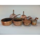 Four graduated 19th century copper saucepans, all with heavy steel handles, together with four pan