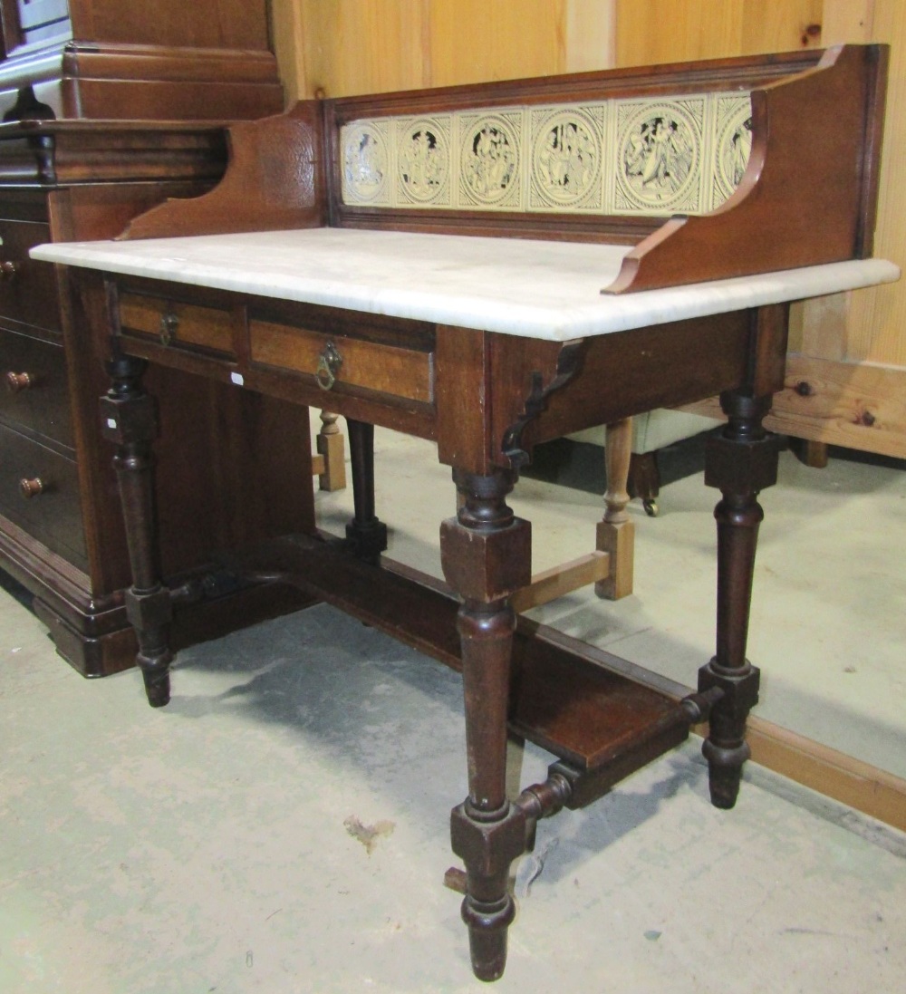 A late Victorian walnut washstand fitted with two frieze, birds-eye maple veneered drawers, raised