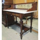 A late Victorian walnut washstand fitted with two frieze, birds-eye maple veneered drawers, raised