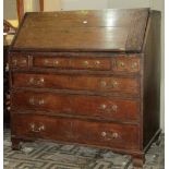 A Georgian oak bureau, the fall flap enclosing a fitted interior of small drawers, pigeon holes