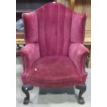 A good quality Edwardian wing back armchair in the Georgian style, with arched and pleated back,