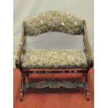 A small low X framed chair, with repeating acanthus and other detail
