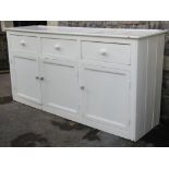 A Victorian pine dresser base fitted with three frieze drawers over three rectangular moulded