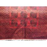 Full pile Bokhara carpet with typical black geometric medallions upon a red ground, 295 x 190cm