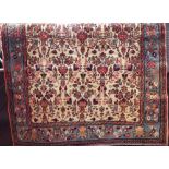 Full pile Persian carpet with various floral still life decoration and light blue borders upon a