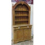 A slender reclaimed stripped pine kitchen dresser, the case enclosed by a pair of shallow pointed,