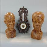 Aneroid barometer with trailing floral detail and two African carved wooden heads