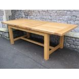 A good quality contemporary light oak pull out extending dining table of rectangular form with