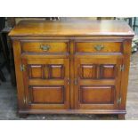 An oak and elm lined side cupboard in the Georgian manner, enclosed by a pair of fielded panel doors