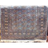 Full pile Bokhara rug with typical geometric medallion decoration upon a blue ground, 180 x 125cm