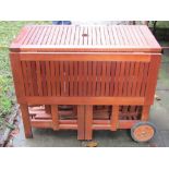 A contemporary hardwood drop leaf garden table with rectangular slatted top and under tier housing