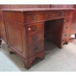 A reproduction Georgian style mahogany veneered kneehole twin pedestal writing desk with inset