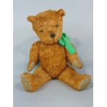 Vintage teddy bear with brown fur, green eyes, green bow, canvas feet and hands (some wear) and