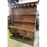 A Georgian oak cottage dresser, the lower section enclosed by an arrangement of five drawers over an