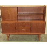 A 1970s teak high board enclosed by an arrangement of cupboards and drawers with sculptural