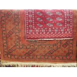 Antique Bokhara rug with three central medallions upon a red ground, 180 x 110cm, together with a