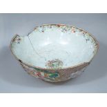 An 18th century Chinese bowl showing characters and landscape, riveted and incomplete, 35 cm