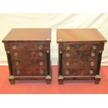 A pair of small Empire style mahogany cabinets each enclosing four frieze drawers, with ebonised