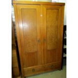 An art deco style two door wardrobe, in mixed woods including rippled ash, the panelled and fluted