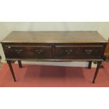 A small 18th century oak dresser base, enclosing two frieze drawers, with turned and tapering