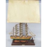 Scratch built model of a clipper ship converted into a twin branch table lamp upon a wooden plinth
