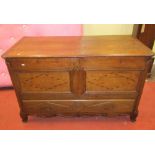 A substantial oak mule chest with rising lid, the front elevation enclosed by two panels, with
