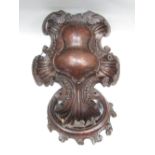 A carved soft wood rococo style hanging of bombe form with wreath crown, 36 cm high