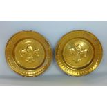 A pair of Arts & Crafts type brass chargers, each centrally embossed with a fleur-de-lys, 36 cm