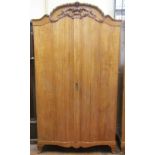 A good quality continental rippled ash wardrobe with shaped and moulded front, enclosed by two doors