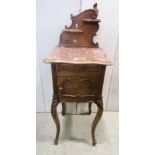 A late 19th century walnut side cabinet with marble lined interior, enclosed by a frieze drawer