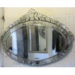 A Venetian style mirror, the oval bevelled edge plate within a further etched mirror frame
