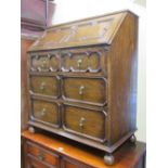 An Edwardian oak bureau in the Jacobean revival manner, enclosing two long and two short drawers,