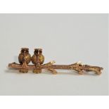 Edwardian novelty brooch in the form of two owls perched on a branch, in 9ct bi-colour gold with