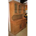 A stripped and waxed pine dog kennel dresser, the base enclosed by three drawers and two