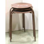 A stack of three vintage stools, with circular plywood seats, raised on tubular steel supports