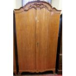 A good quality continental rippled ash wardrobe with shaped and moulded front, enclosed by two doors