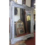 A large wall mirror of rectangular form with bevelled edge plate within a deep swept and moulded