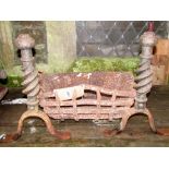 A small ironwork fire basket and loose dogs with open spiral twist stems and swept flattened feet,