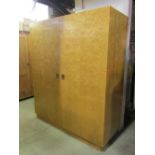 A good quality figured maple veneered compactum wardrobe enclosed by a pair of full length deep