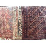 Three antique Persian carpets to include a Persian geometric design on black ground, 180 x 105cm,