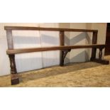 An oak bench/pew with moulded rail back over a plank seat, raised on turned and block supports,