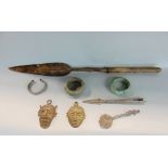 A collection of interesting ethnic finds to include two bangles, two masks, a spoon, and two spear