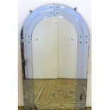 An Art Deco wall mirror of arched outline, the central mirror plate enclosed within a two tier