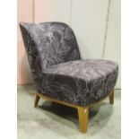 An Ikea Sthlm easy chair, with shaped outline, with leaf printed patterned upholstery