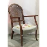 Two similar open elbow chairs, with floral tapestry upholstered seats and cane panelled back