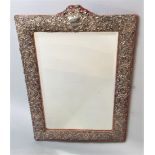 Large silver applied easel mirror, embossed with various foliage and scrolled cartouche fitted