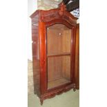 A 19th century mahogany armoire enclosed by a full length arched and moulded glazed panelled door